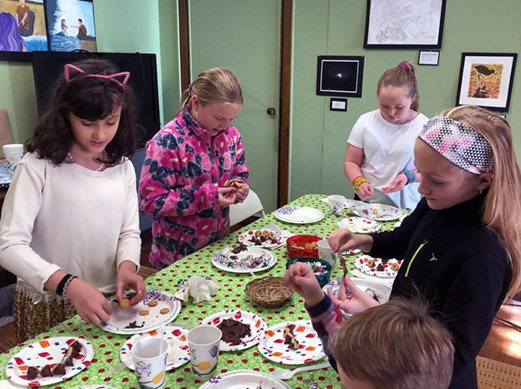 Kids gathered around the table working on an art project.